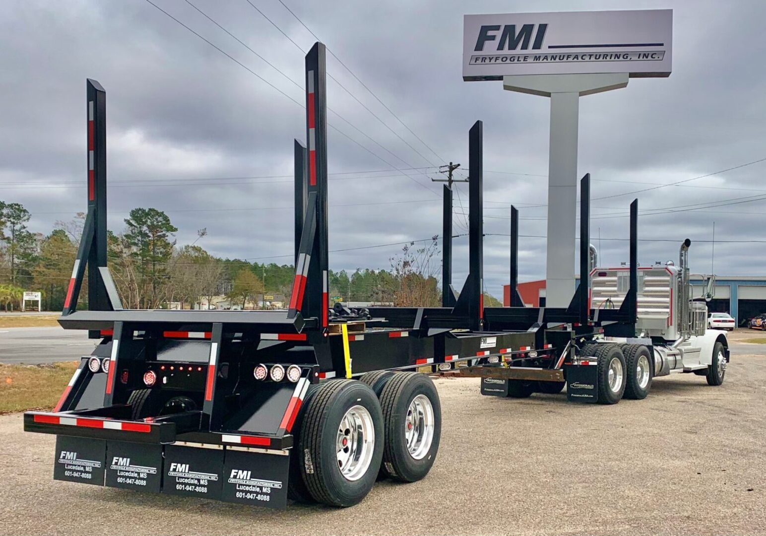 Long black timber bolster trailer at dealership