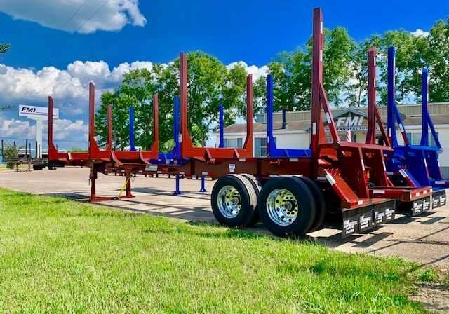 Red and blue logging trailers parked outside